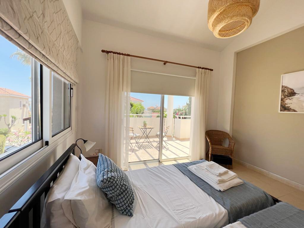 Bedroom with a dark wooden bedstead and glazed doors opening onto a private balcony