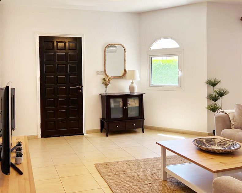 Panelled front door, mirror and console cabinet where the hall meets the living area