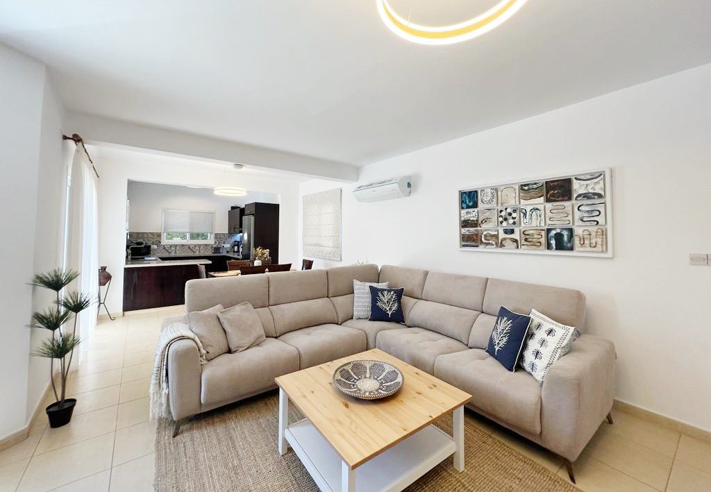 Large corner sofa and coffee table in the open-plan lounge, kitchen visible beyond