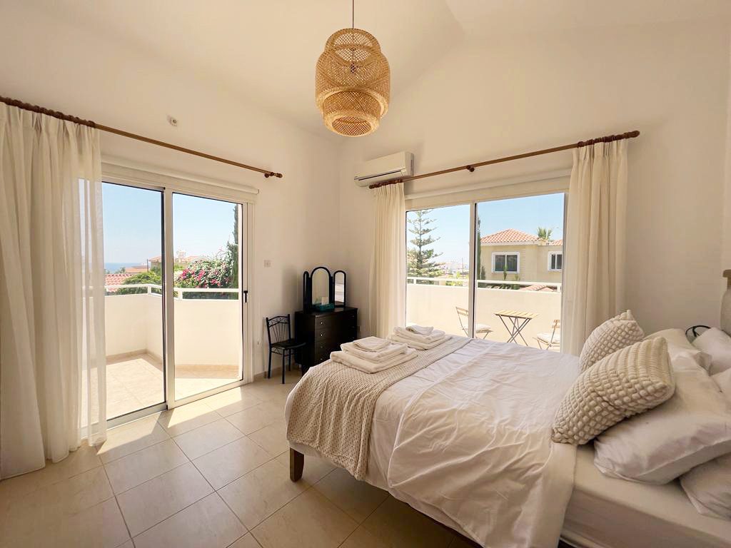 Airy master bedroom with double bed and two sets of doors onto the balcony