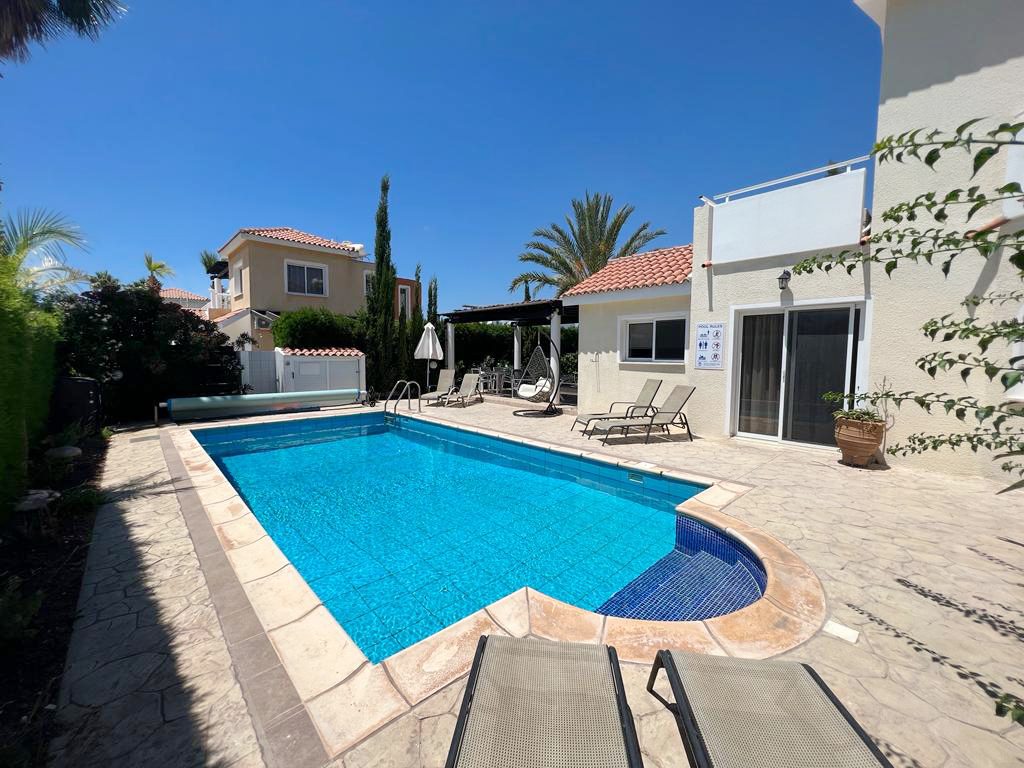 The whole private pool with its curved step corner, loungers and the villa behind