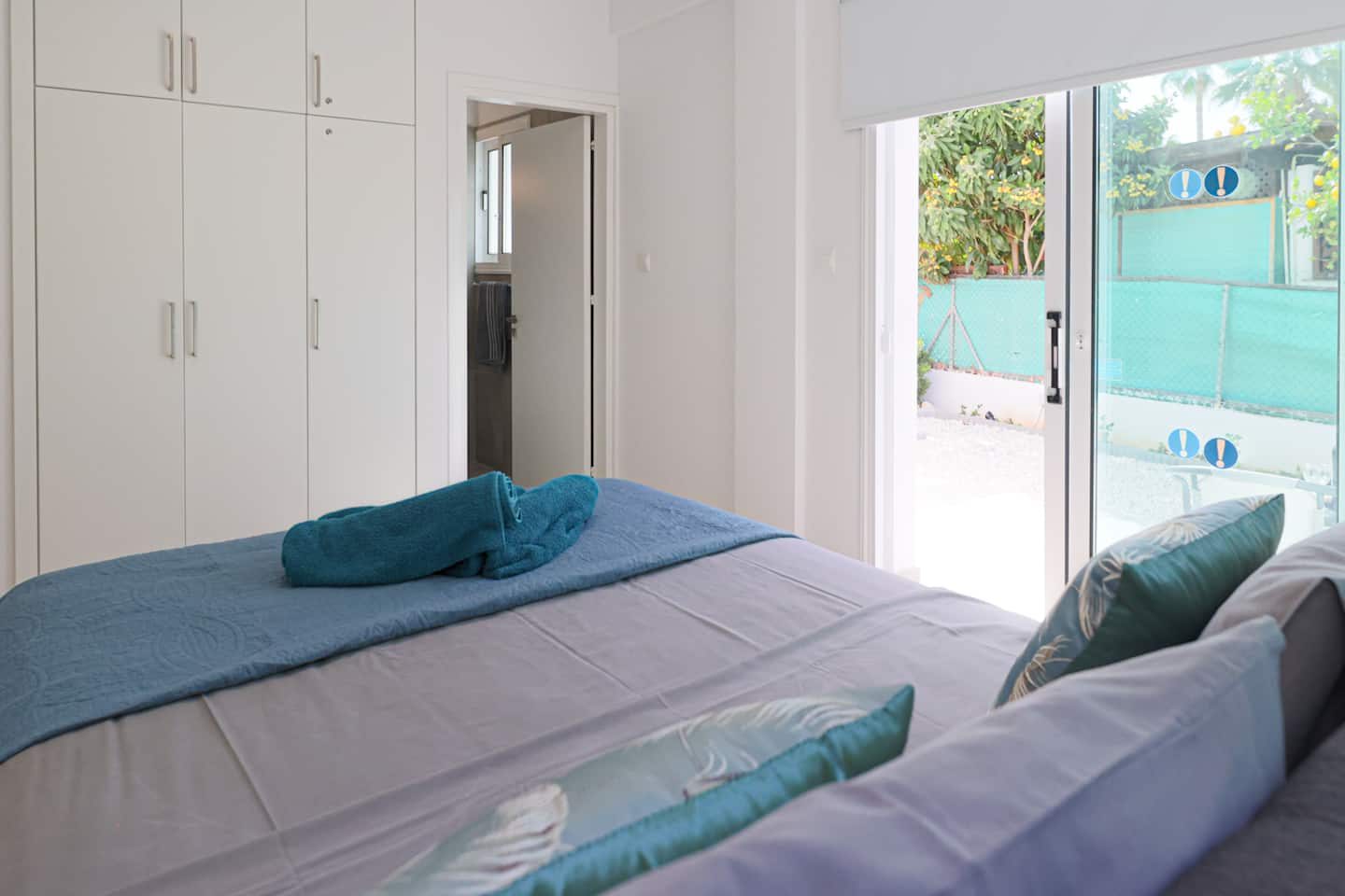 Bedroom with fitted wardrobes, en-suite doorway and sliding doors to the garden